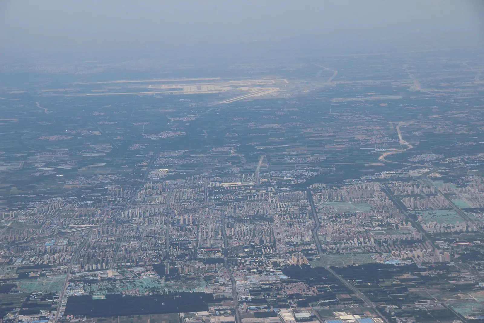 从空中俯瞰廊坊城区，远处为北京大兴国际机场